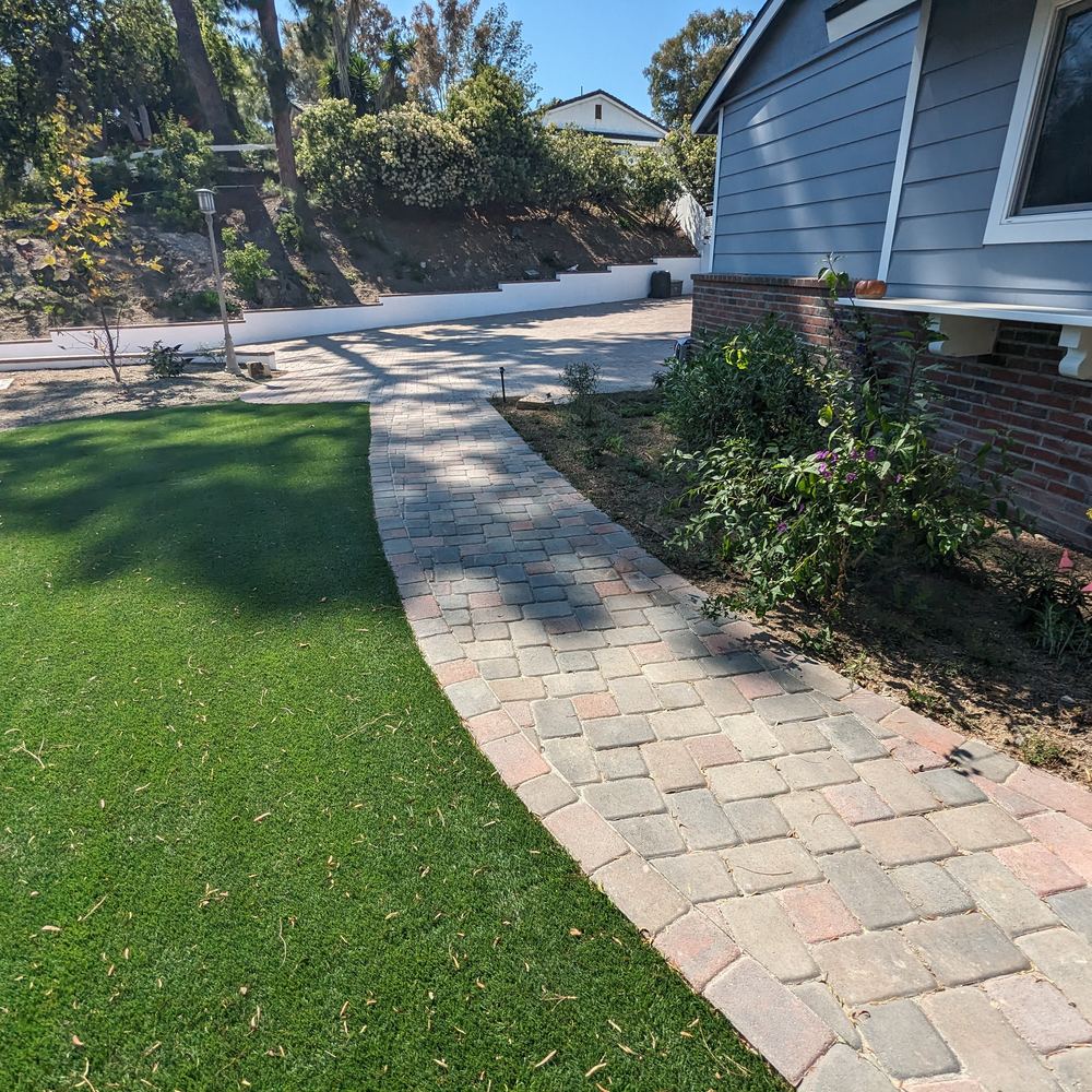Curved paver walkway through a green lawn