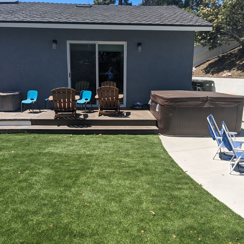 Backyard lawn leading up to a deck and patio